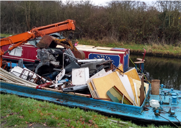 Narrowboat on a canal covered in debree.